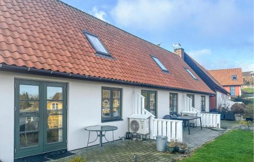a white house with an orange roof and a table at Stunning Home In Gudhjem With Sauna in Gudhjem