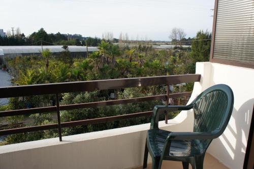 a green chair sitting on a balcony with a view at Hotel Contriz in Póvoa de Varzim