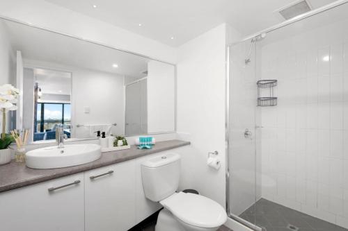 a bathroom with a toilet and a sink and a shower at City Chic, Elegant 2BR apt in Perth