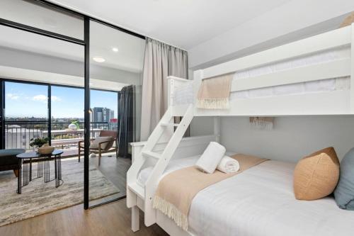 a bedroom with a bunk bed and a balcony at City Chic, Elegant 2BR apt in Perth
