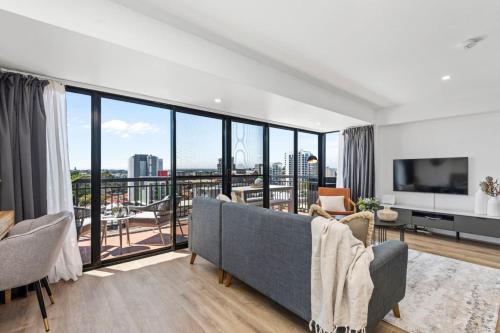 a living room with a couch and a large window at City Chic, Elegant 2BR apt in Perth