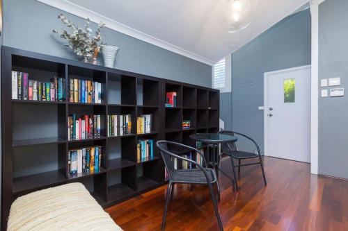 a living room with a book shelf filled with books at Fusion of 20th century charm and modern convenience in Perth