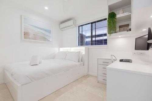 a white living room with a white couch and a window at The Little Peaceful Retreat, 600m to Scarb Beach in Perth