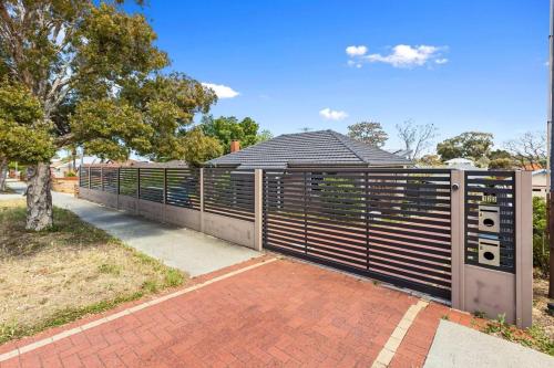 a fence in front of a house with a tree at Sasha's Cottage on the Hill BBQ & Entertainment in Perth