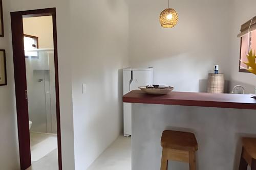 a kitchen with a counter and a refrigerator at Licuri Praia de Algodões à poucos passos do mar. in Marau