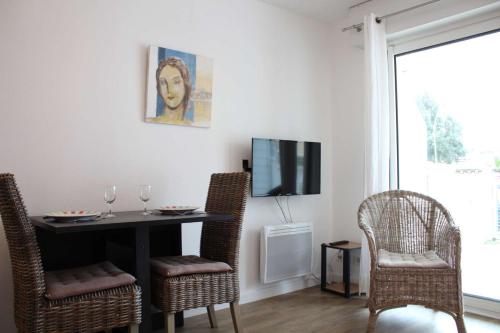 シャトライヨン・プラージュにあるAppt 2 pièces CHATELAILLON PLAGE - CL090-018のテーブルと椅子とテレビのあるダイニングルーム