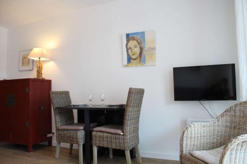 シャトライヨン・プラージュにあるAppt 2 pièces CHATELAILLON PLAGE - CL090-018のテーブルと椅子とテレビのあるダイニングルーム