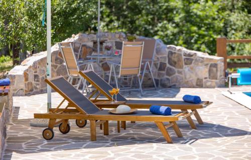 two lounge chairs and a table and a table and chairs at Awesome Home In Gracac With Sauna in Gračac