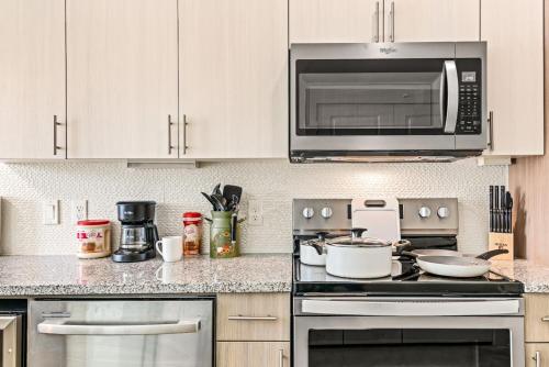 a kitchen with a stove and a microwave at Serene Escape 1BD Pool 2 min to TCU in Fort Worth