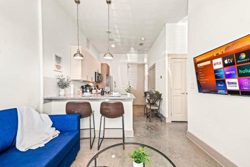 a living room with a blue couch and a kitchen at Serene Escape 1BD Pool 2 min to TCU in Fort Worth