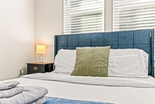 a bed with a blue headboard and a green pillow at Serene Escape 1BD Pool 2 min to TCU in Fort Worth