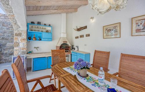 a kitchen with blue cabinets and a table and chairs at Lovely Home In Selina in Selina