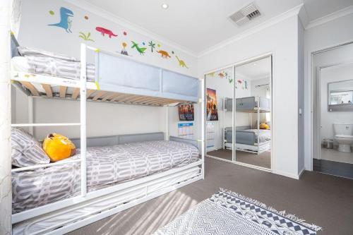 - une chambre avec 2 lits superposés et un miroir dans l'établissement Modern Family Friendly Retreat Home with Sunroom, à Clyde North