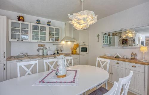 a kitchen with a white table and white cabinets at Lovely Home In Selina in Selina
