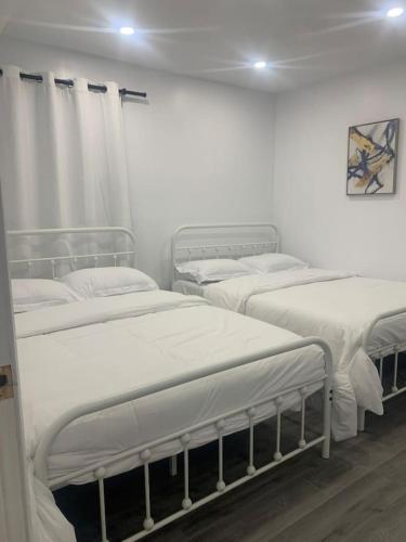 three beds in a room with white walls at Cozy 2BR1BA apt in SilverSpeing in Silver Spring
