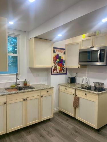 a kitchen with white cabinets and a microwave at Cozy 2BR1BA apt in SilverSpeing in Silver Spring