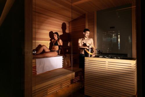 a man and a woman standing in a bath tub at Hotel Intermonti in Livigno