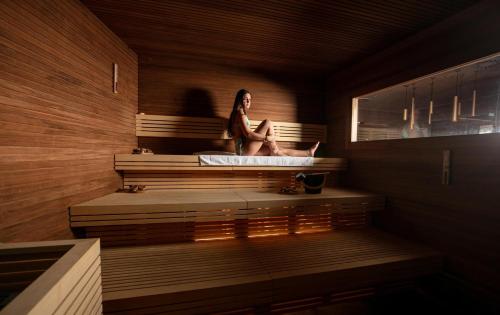 a woman sitting in a bath tub in a room at Hotel Intermonti in Livigno