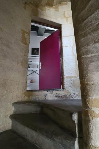 une porte menant à une chambre avec une porte violette dans l'établissement La Tour des Songes Place Dampmartin Uzès, à Uzès