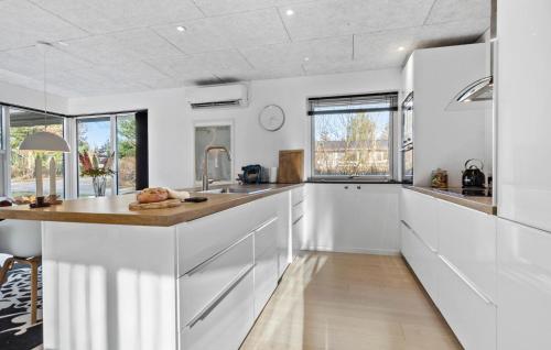 a kitchen with white cabinets and a counter top at Beautiful Home In Glesborg in Glesborg