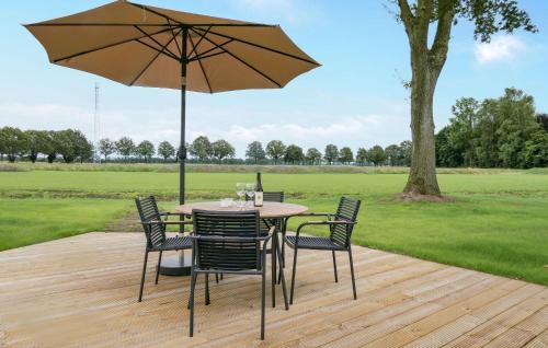 a table with chairs and an umbrella on a wooden deck at Gorgeous Home In Afferden With Wifi in Afferden