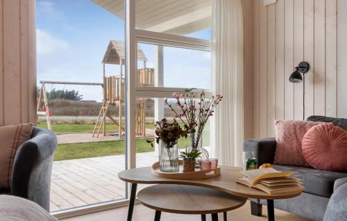 a living room with a table in front of a window at Pet Friendly Home In Løkken With Sauna in Løkken