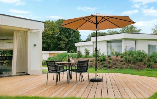 a table and chairs with an umbrella on a deck at Gorgeous Home In Afferden With Wifi in Afferden