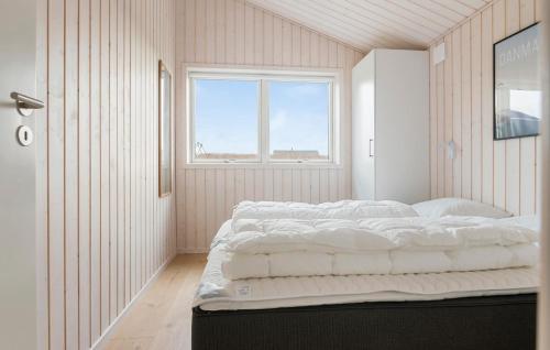 a bedroom with a large bed with a window at Pet Friendly Home In Løkken With Sauna in Løkken