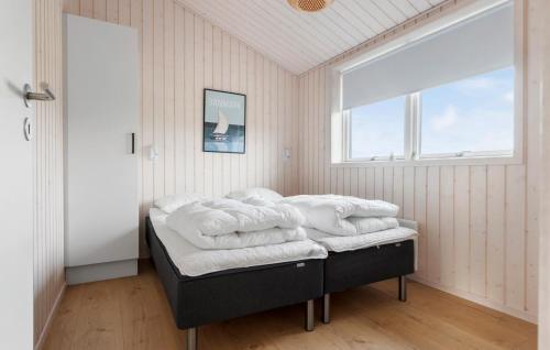 a room with a bed with white towels on it at Pet Friendly Home In Løkken With Sauna in Løkken
