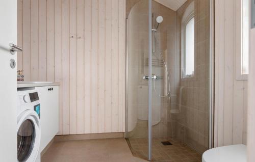a bathroom with a shower and a washing machine at Pet Friendly Home In Løkken With Sauna in Løkken