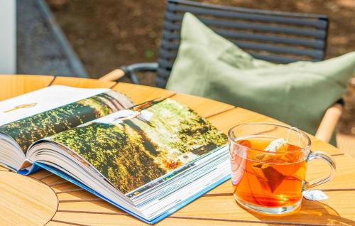 an open book and a cup of tea on a table at 2 Bedroom Stunning Home In Afferden in Afferden