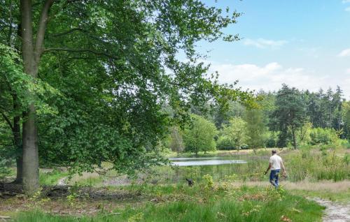 a man is walking in a field with a stick at 2 Bedroom Stunning Home In Afferden in Afferden