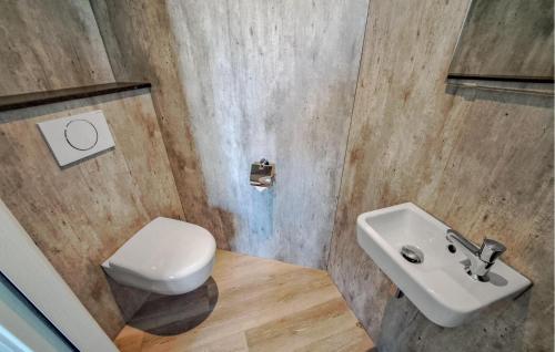 a bathroom with a white toilet and a sink at 2 Bedroom Stunning Home In Afferden in Afferden