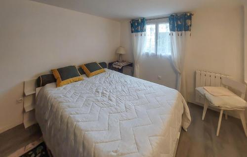 - une chambre avec un grand lit blanc et des oreillers jaunes dans l'établissement 1 Bedroom Amazing Home In Bléré, à Bléré