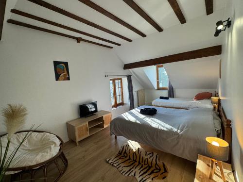 a bedroom with a bed and a tv in it at La Chaumière du bout du chemin - 7p - Ch RDC in Neuville-sur-Touques