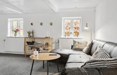 a living room with a couch and a table at 4 Bedroom Awesome Home In Grenaa in Grenå