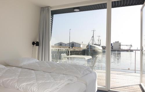 a bedroom with a bed and a balcony with a boat at 3 Bedroom Amazing Ship In Nexø in Neksø
