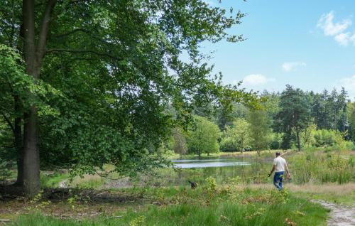 a man holding a fishing rod in a field near a river at 2 Bedroom Stunning Home In Afferden in Afferden