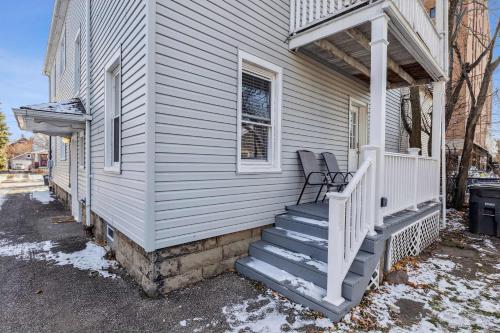 a white house with a porch with a chair on it at Tiny Taco House in Lakewood