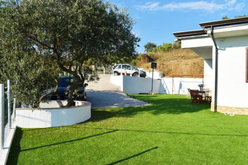 a yard with a tree and a white fence at Villa panoramica con idromassaggio in cilento in Matonti