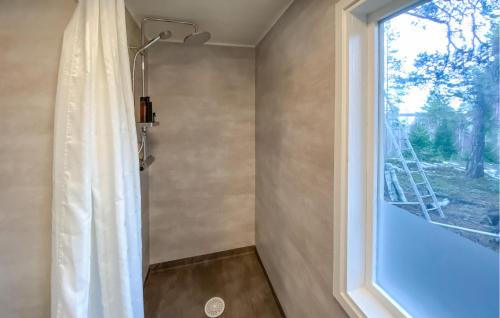 a bathroom with a shower curtain and a window at 3 Bedroom Amazing Home In Yxlan in Yxlö