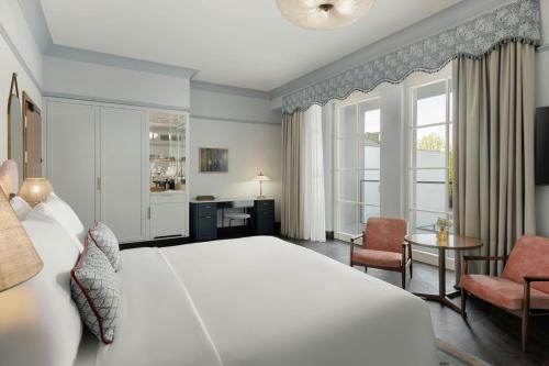a bedroom with a large white bed and a desk at Stradom House, Autograph Collection in Kraków