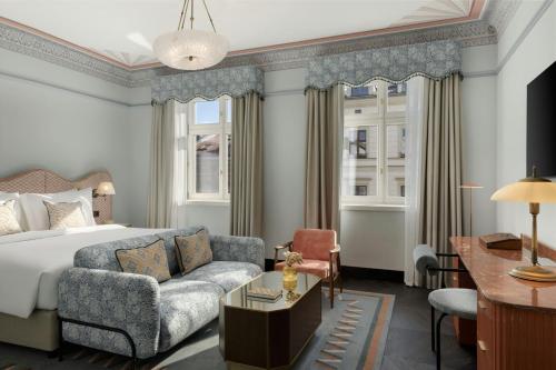 a hotel room with a bed and a couch at Stradom House, Autograph Collection in Kraków