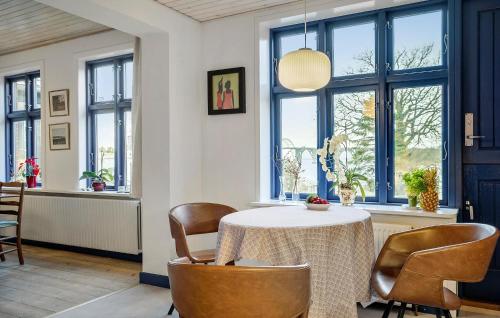 a dining room with a table and chairs and windows at 2 Bedroom Beautiful Home In Kalvehave in Kalvehave