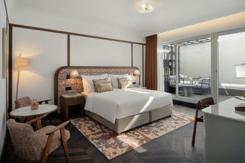 a bedroom with a large bed and a living room at Stradom House, Autograph Collection in Kraków