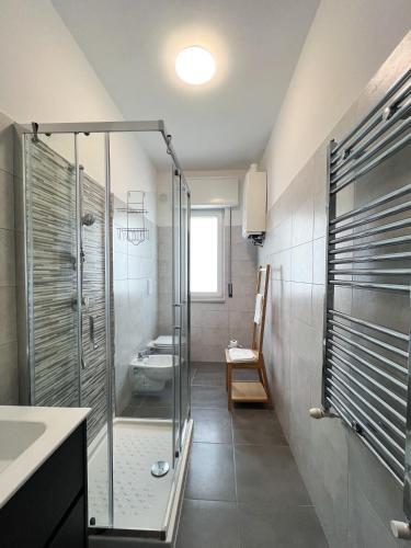 a bathroom with a glass shower and a sink at Isabel apulian apartment in Molfetta