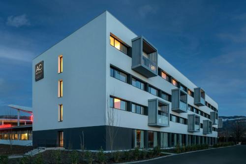 une vue sur l'extérieur d'un bâtiment avec un éclairage bleu dans l'établissement AC Hotel by Marriott Saint-Julien-en-Genevois, à Saint-Julien-en-Genevois