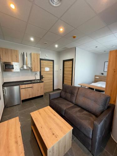 a living room with a couch and a kitchen at Apartamentos - Mirasur in Parla