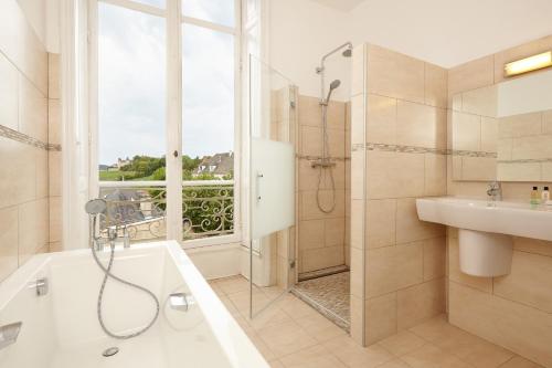uma casa de banho com uma banheira, um chuveiro e um lavatório. em Château Saint-Michel - Cercle des Grands Crus em Rully