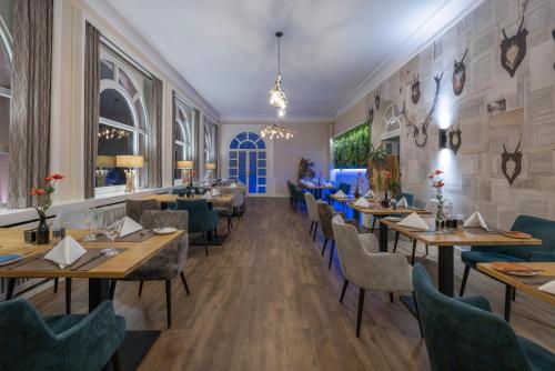 a restaurant with wooden tables and blue chairs at Fletcher Waldhotel Nordrhein-Westfalen in Heiligenhaus